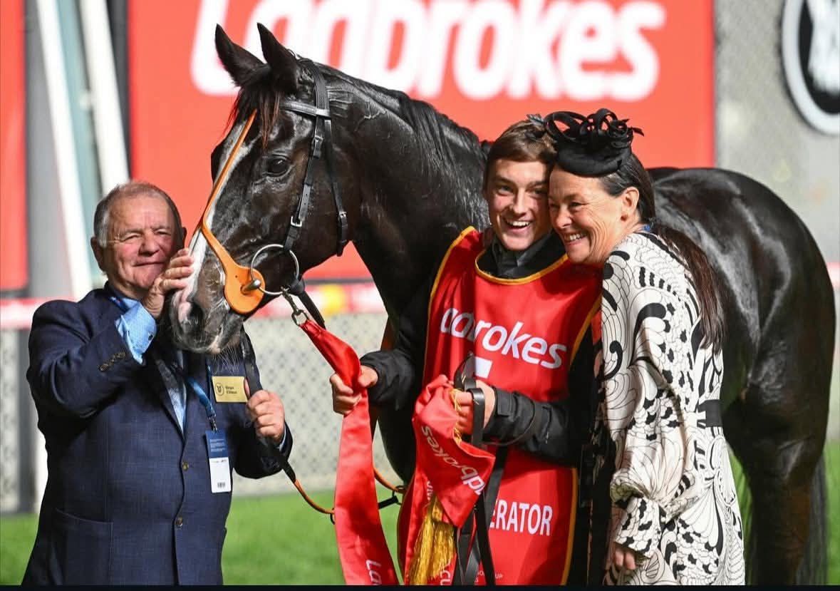 Horse, trainer, jockey, and owner celebrating together in a winner’s circle